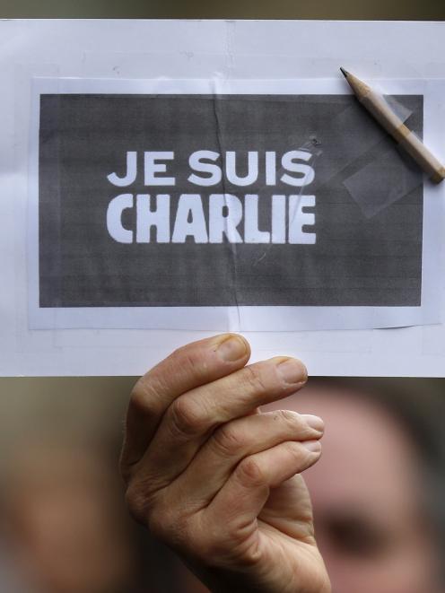A person holds a placard with a pencil which reads "I am Charlie" during a minute of silence in...