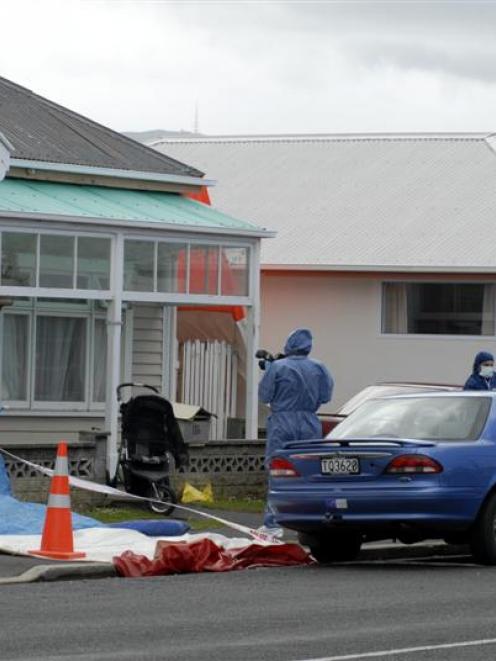 A photographer studies a child's buggy as ESR scientists and police examine the scene of a fatal...