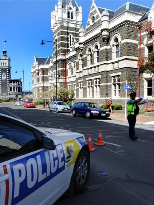 A police officer diverts traffic away from the Dunedin court house yesterday. Photos by Staff...