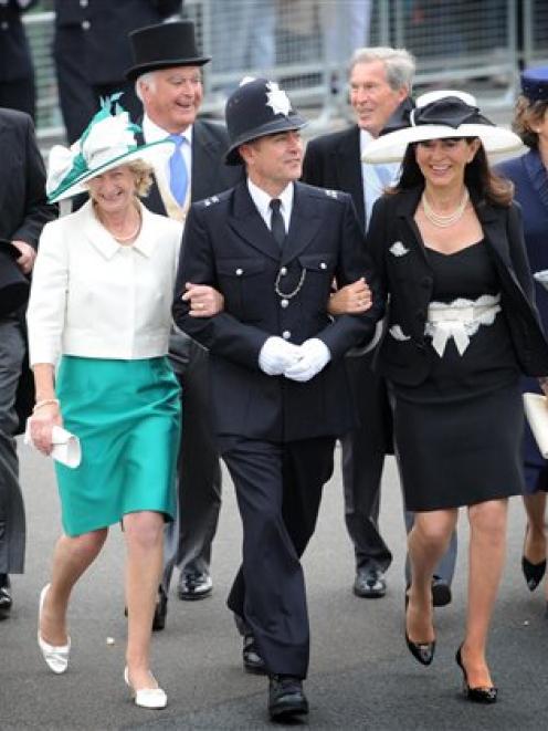 A police officer escorts guests arriving at the wedding of Prince William and Kate Middleton at...