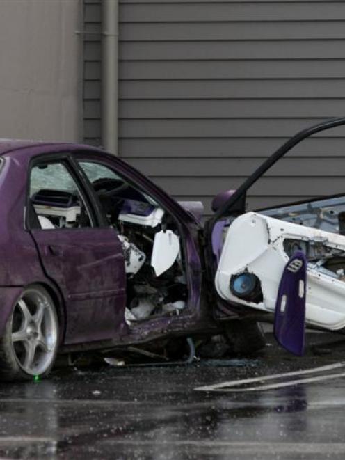 A police officer examines the car in which three teenagers were killed in Invercargill early this...