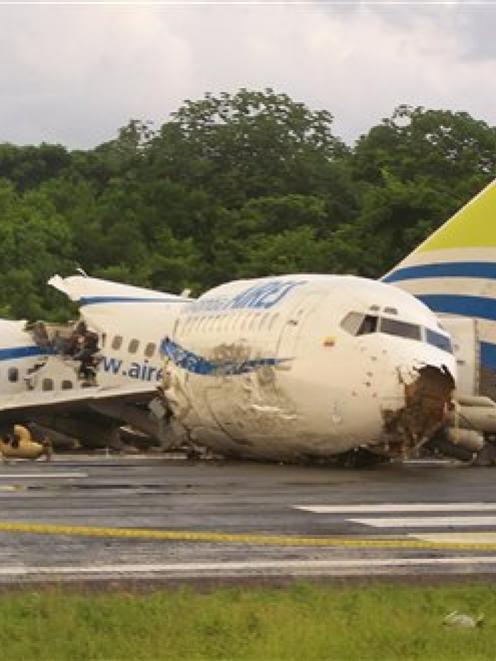 A police officer stands by a crashed plane sitting on the runaway at the airport on San Andres...