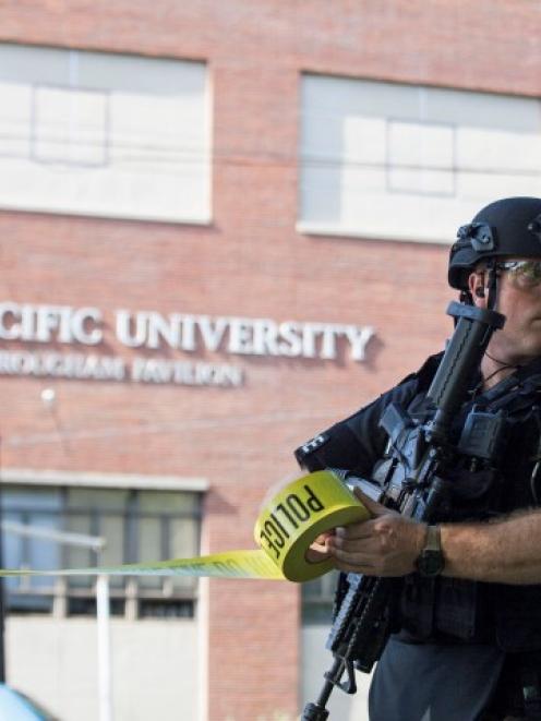 A policeman helps secure the scene at Seattle Pacific University after the campus was evacuated...