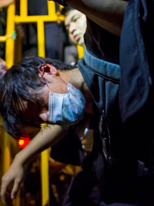 A pro-democracy protester is detained by police during a confrontation at Mong Kok shopping...