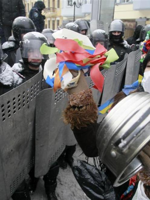 A pro-European protester stands in front of riot police.  Photo by Reuters.