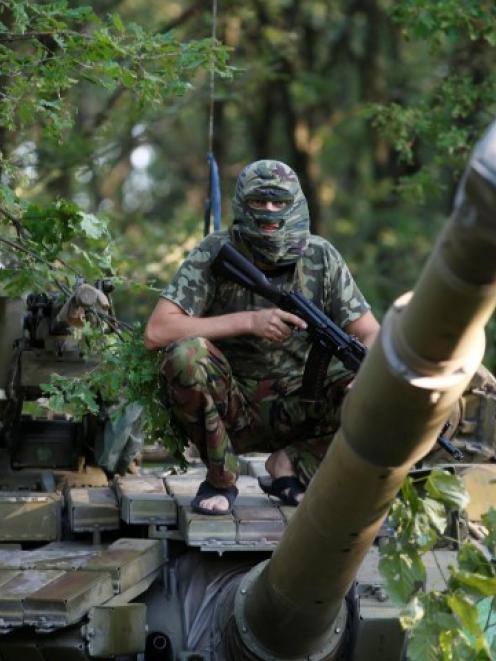 A pro-Russian separatist from the Vostok (East) battalion sits atop a T-64 tank in Donetsk,...