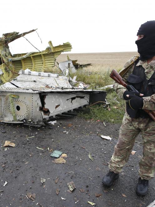 A pro-Russian separatist stands at the crash site of flight MH17. Photo by Reuters.