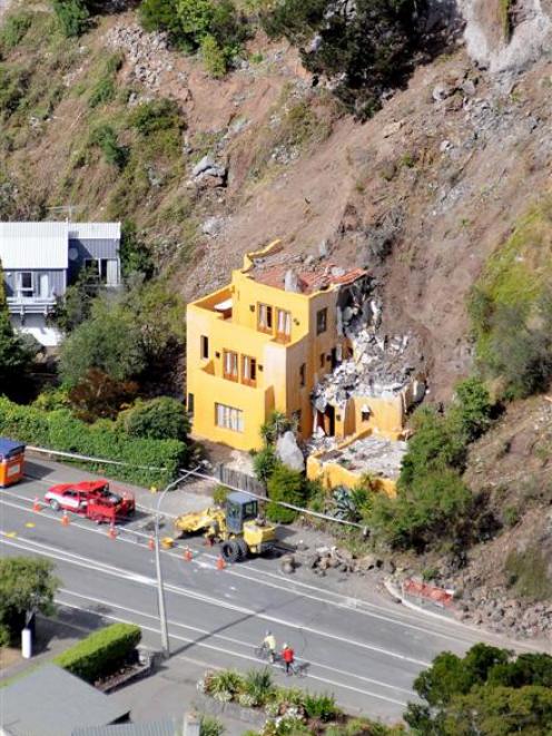 A property in Redcliffs lies partly buried under rubble from the cliff above. Photo by NZPA.