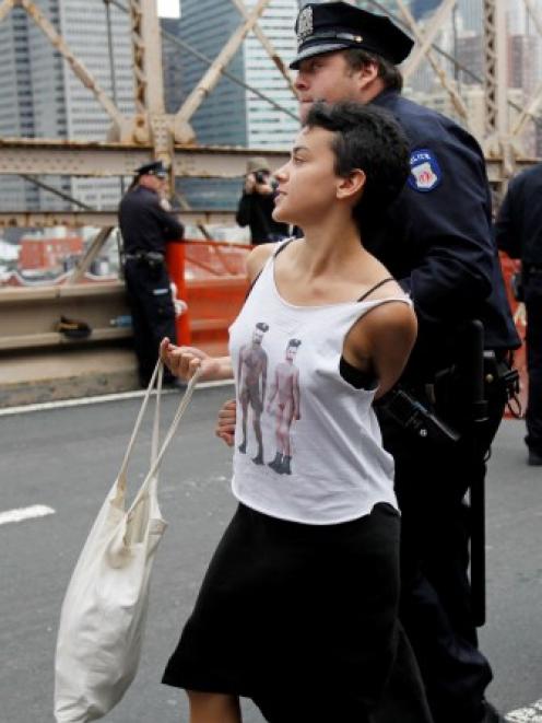 A protester reacts as she is arrested on the Brooklyn Bridge during an Occupy Wall Street march...
