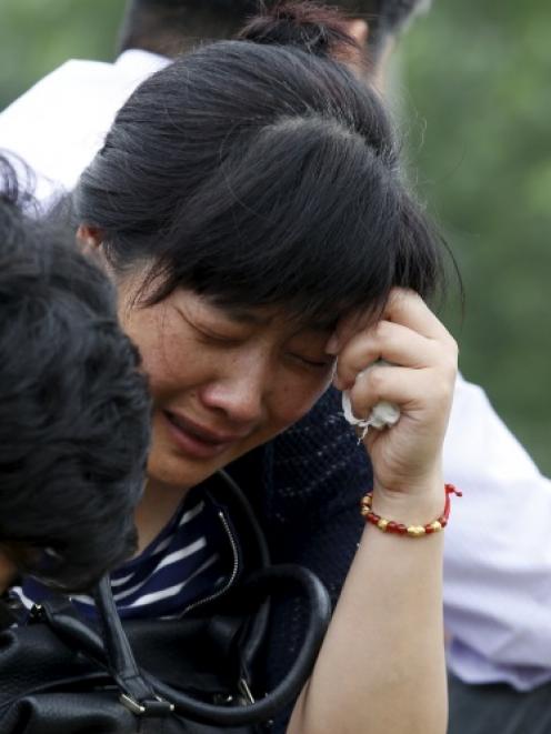 A relative of a passenger of the sunken cruise ship cries on a road to the site of the sinking in...