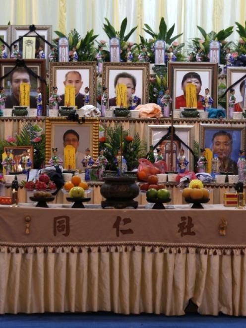 A relative pays her respect in front of portraits of passengers who died in a TransAsia Airways...