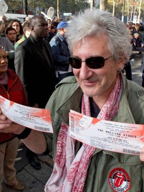 A Rolling Stones fan displays two tickets he purchased for a short warm-up gig in Paris. REUTERS...