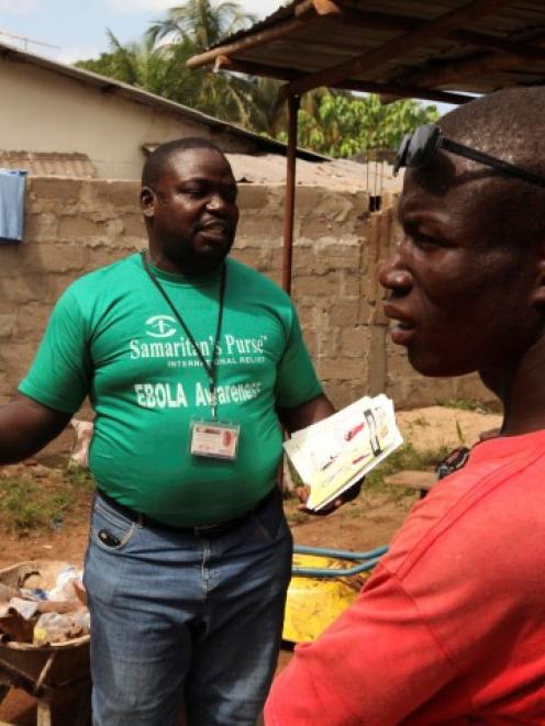 A Samaritan's Purse team member hands out pamphlets to educate the public on the Ebola virus in...