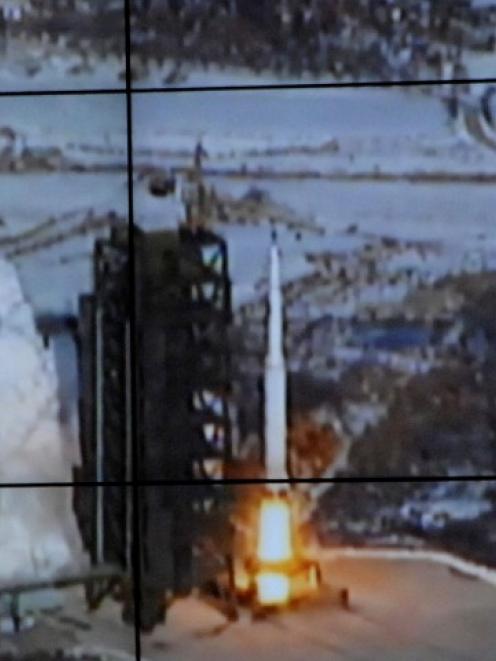 A screen shows the Unha-3 (Milky Way 3) rocket being launched from a launch pad at the North...