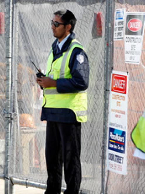 A security guard keeps watch on the closed Mainzeal construction site at Shed 10, Queens Wharf....