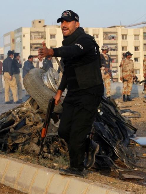 A security officer yells for help at the site of a bomb attack which killed Chaudhry Aslam....