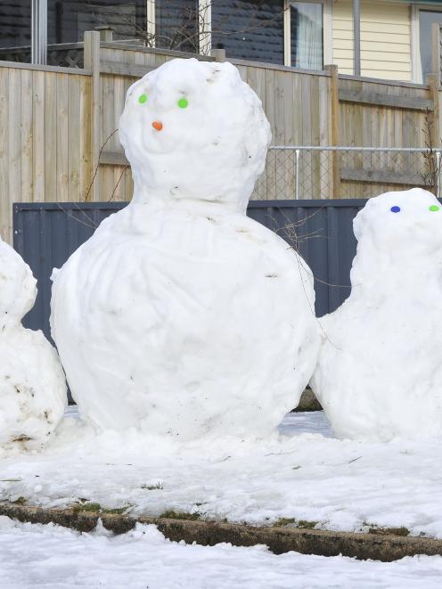 A snow family in Ashmore St, Halfway Bush, yesterday. Photo by Craig Baxter.