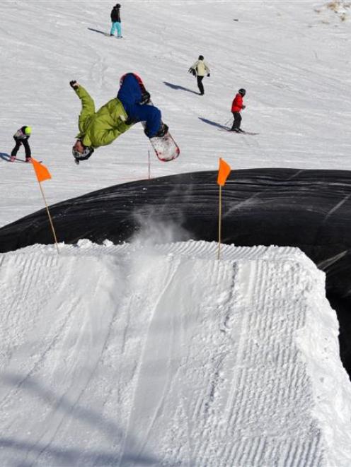 A snowboarder practises jumps and tricks into  a ''super-sized'' air bag fall cushion. ACC is...