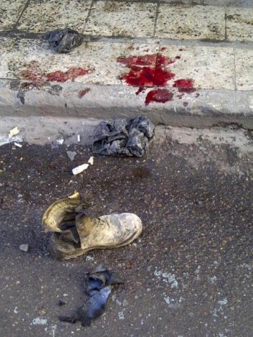 A soldier's boot and blood stains are seen on the ground after a bomb attack occurred in Alawi...