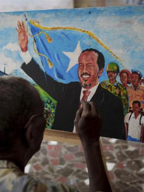 A Somali artist paints an impression of Somalia's President Hassan Sheikh Mohamud in  the Somali...