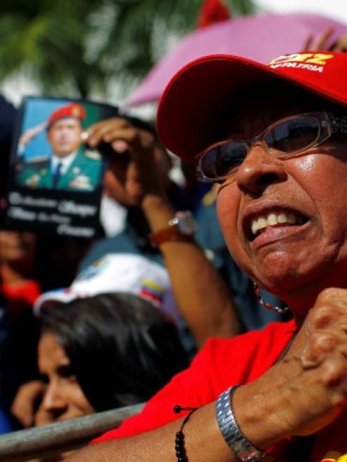 A supporter of Venezuela's late President Hugo Chavez waits for a chance to view his body lying...