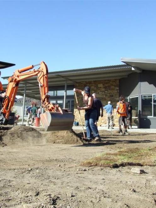 A team of volunteers, including Delta staff and Alexandra Lions Club members, work on landscaping...