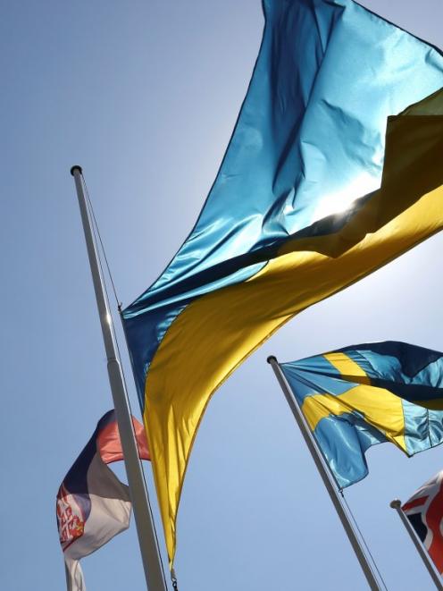 A Ukrainian national flag flies at half-mast near other European flags outside the headquarters...