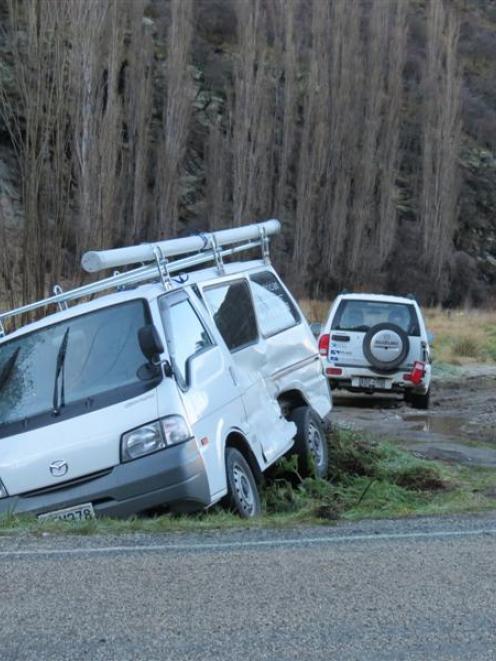 A van and a four-wheel-drive vehicle sit stranded after black ice caused a three-car pile-up on...
