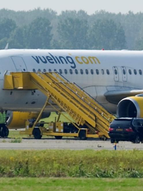 A Vueling plane sits by a field near Amsterdam Airport after a hijack scare which led the...