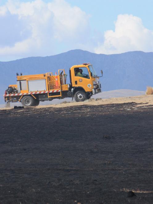A water tanker is driven past grassland blackened by fire at Cornaig Farm, near Wedderburn. Photo...