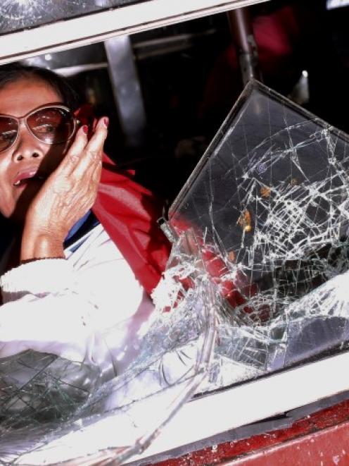 A woman cowers inside a bus as it is attacked by anti-government protesters near the stadium...