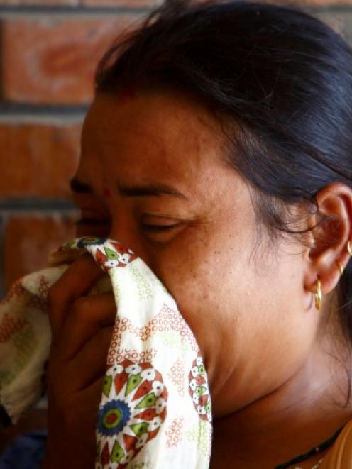 A woman cries as she arrives at a hospital in Kathmandu, where loved ones are undergoing...