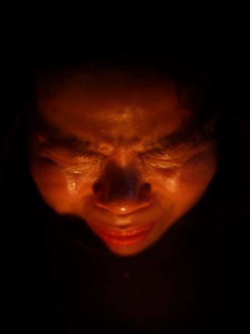 A woman cries while praying during a candlelight vigil in Ansan, to commemorate the victims of...