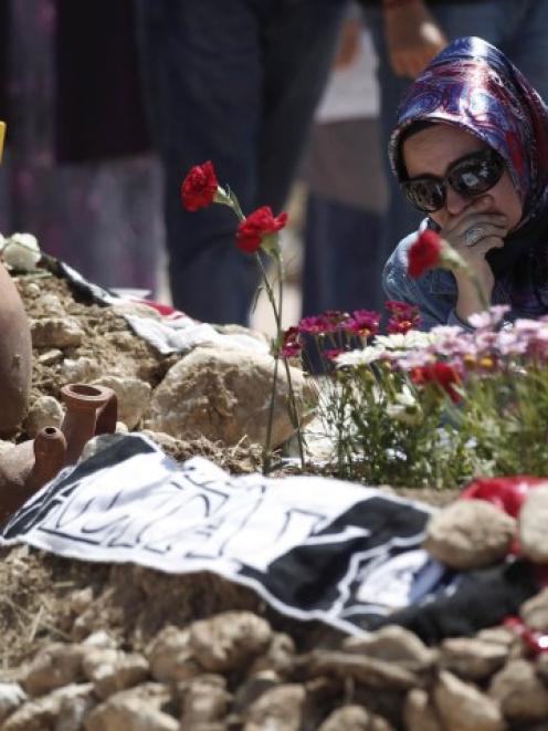 A woman mourns at graves for men killed in the mine disaster, at a cemetery in Soma, a district...