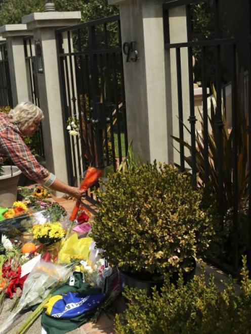 A woman places flowers and a card outside the home of actor Robin Williams in Tiburon, California...