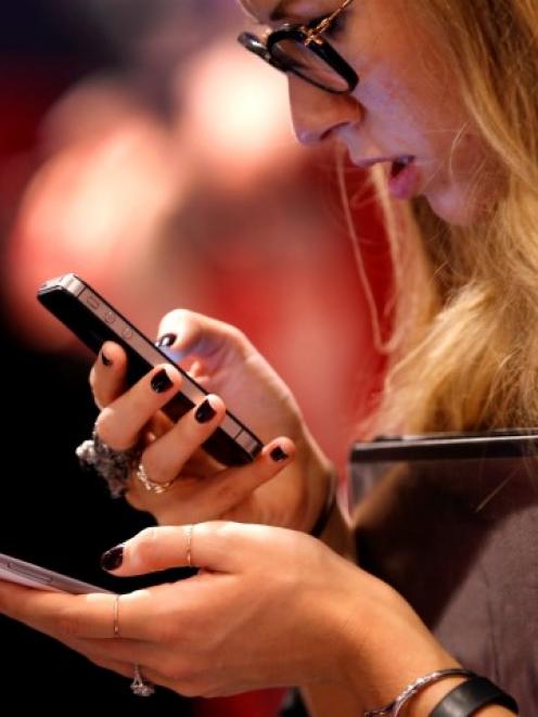 A woman uses a smartphone in New York City. REUTERS/Mike Segar