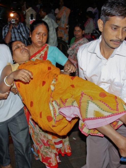 A woman who was injured by a stampede after an earthquake is carried to a hospital in the eastern...