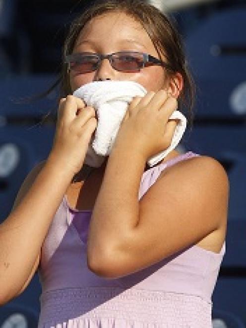 A young fan attempts to stay cool before a MLB baseball game between the Washington Nationals and...