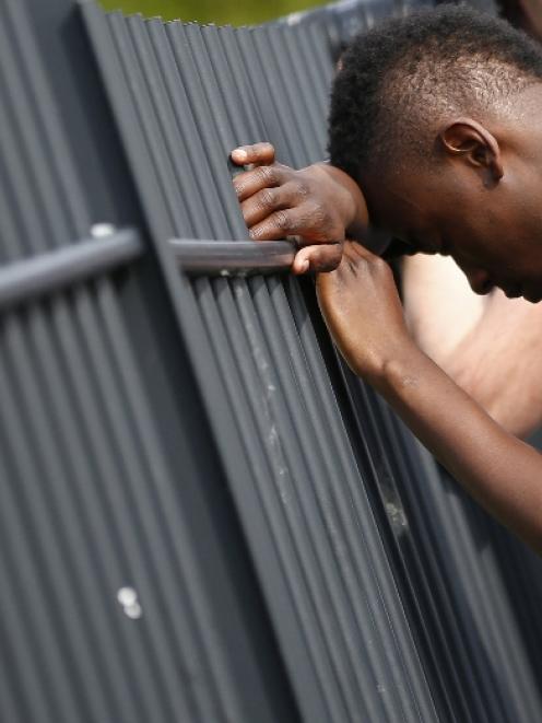 A youth leans against the fence surrounding Corpus Christi Catholic College after teacher Anne...