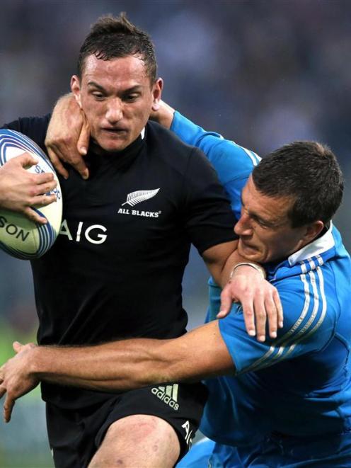 Aaron Cruden is tackled by Alberto Sgarbi of Italy. REUTERS/Alessandro Bianchi