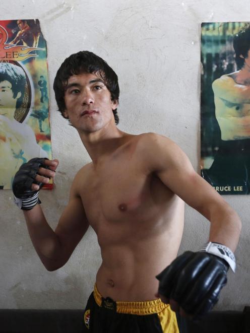 Abbas Alizada, who calls himself the Afghan Bruce Lee, poses in front of Bruce Lee posters in...