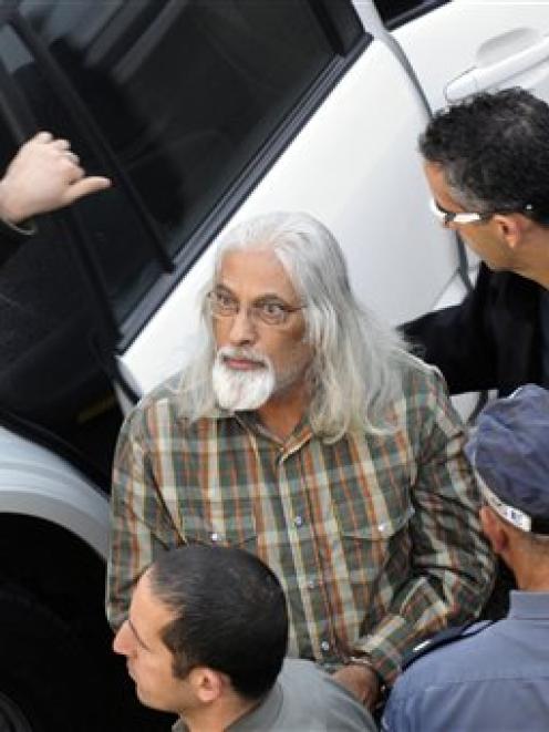 Accused harem leader Goel Ratzon, centre, is escorted by Israeli Police officers to a Tel Aviv...