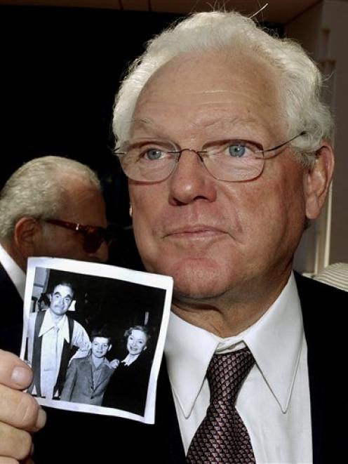 Actor James MacArthur holds a photo from the late 1940s, of himself as a child with his mother,...