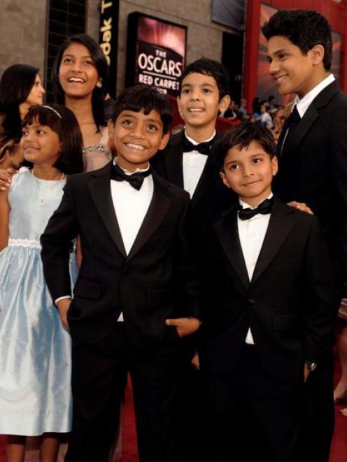 Actor Sir Ben Kingsley, right watches as cast members of the film 'Slumdog Millionaire' arrive...