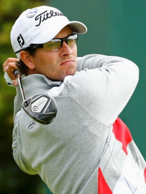 Adam Scott of Australia watches his tee shot on the 15th hole during the first round of the...