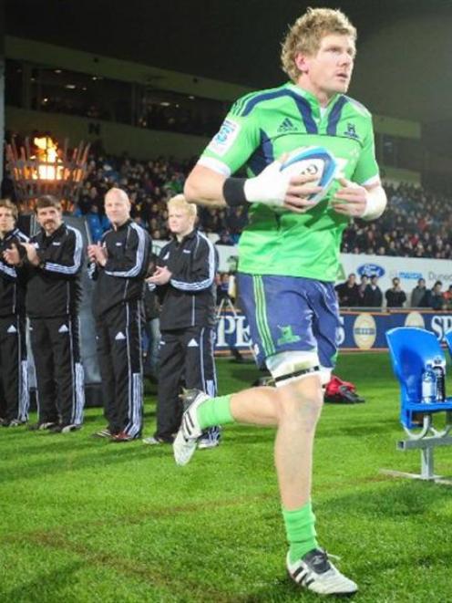 Adam Thomson, of the Highlanders, unveils the new green strip at Carisbrook last Friday night....