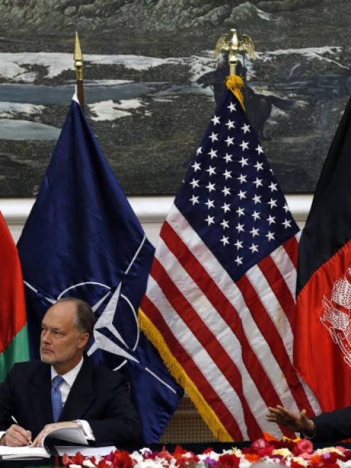 Afghan national security adviser Hanif Atmar (R) and U.S. Ambassador James Cunningham sign the...