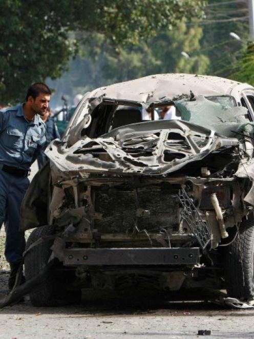 Afghan policemen inspect a vehicle hit by a bomb blast in Jalalabad province earlier this week....
