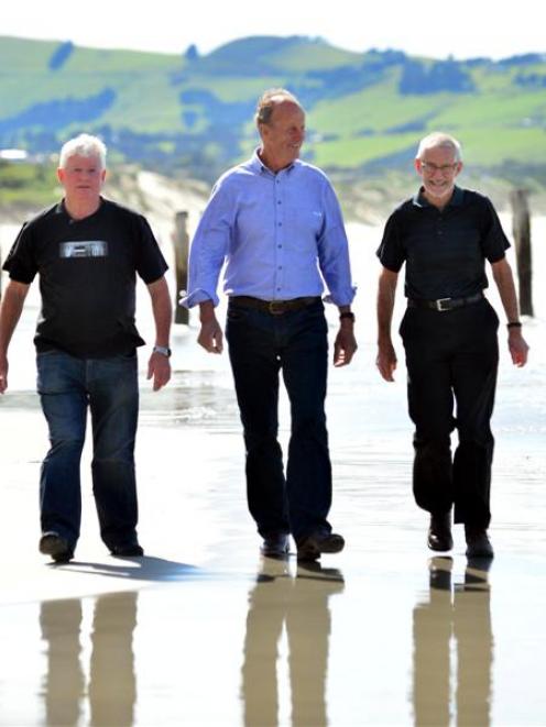Alan Jordan (left) walks down St Clair Beach on Saturday with  surf life-savers Sandy McDowell ...