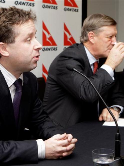 Alan Joyce, chief executive designate of Qantas, left, comments as CEO Geoff Dixon, right, and...